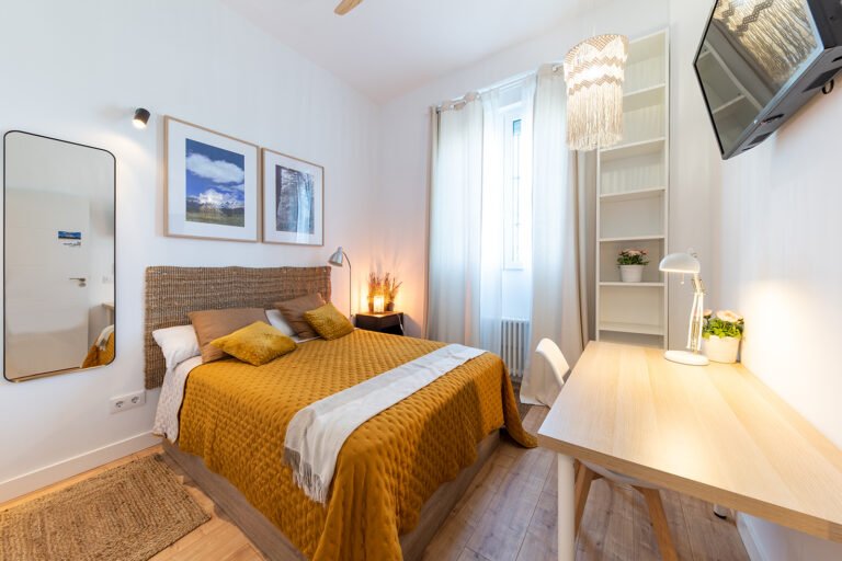 Dormitorio reformado con cama doble y zona de estudio